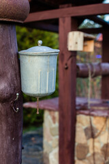 An old village washstand hangs on a pole. Metal washbasin with water and sink for draining water. Concept Of Village Life