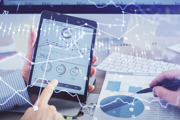 Multi exposure of man's hands holding and using a phone and financial chart drawing. Market analysis concept.