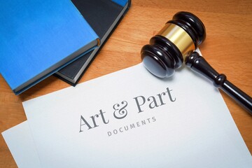 Art & Part. Document with label. Desk with books and judges gavel in a lawyer's office.