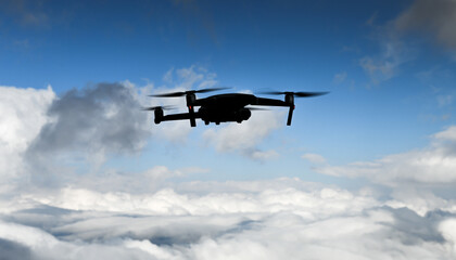 UAV drone silhouette with blue sky cloudy background