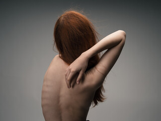 Woman hugging herself with hands back view nude back model