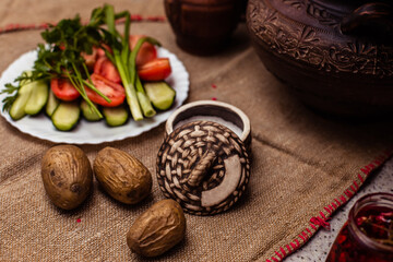 Boiled fresh potatoes in uniform on a wooden board in a cast-iron pan. Russian cuisine. Dinner in the Russian village. salt are on the table. On the background of clay pots