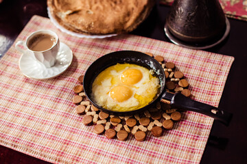 Elegant Restaurant Plate of Fried Eggs Decorated with Fresh Spinach Leaves and Young Pea Shoots on Flat Black Plate. Macro Photo of Healthy Nutritious Breakfast Isolated on White Background