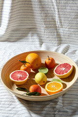 food, healthy eating and vegetarian concept - close up of citrus fruits on wooden plate