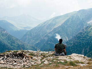 Fototapeta premium Man relax in the mountains on nature beautiful landscape fresh air fog sunlight