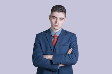 Portrait of a young boy in a suit with his arms crossed