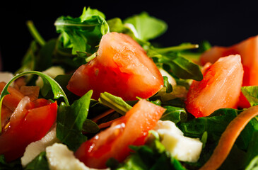 Mixed salad bowl with lettuce, tomato, arugula and mozzarella cheese.