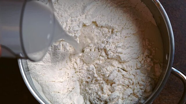 Italian Pizza Dough. the cook adds water and yeast to the flour. DIY homemade dought concept.
