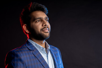 Indian young businessman on dark background