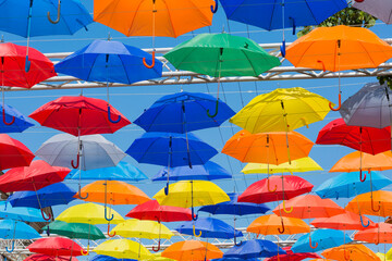 Fototapeta na wymiar Street decorated with colored umbrellas in sunny day