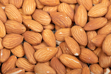 Almonds scattered on the table. Close-up, selective focus.