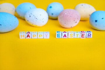Easter greeting card with painted eggs. Seasonal Easter message Happy easter. Pastel and colorful decorated easter eggs with greeting card with text on yellow background. Spring holidays concept. 
