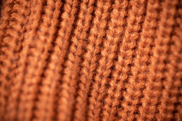 Orange wool scarf background texture. Macro photo with selective focus.