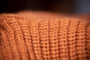 Orange wool scarf background texture. Macro photo with selective focus.