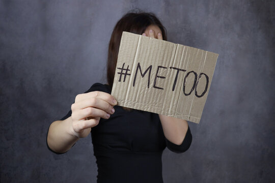 young woman covers her face with a metoo banner