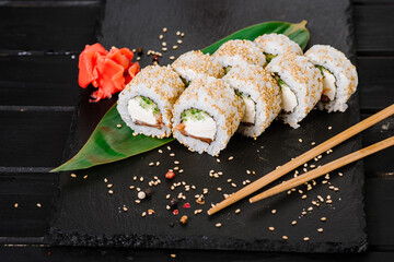 Fresh and tasty sushi rolls on black background