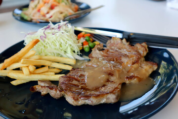 pork steak with French fries and salad