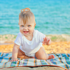 Happy baby kid is enjoying on the beach