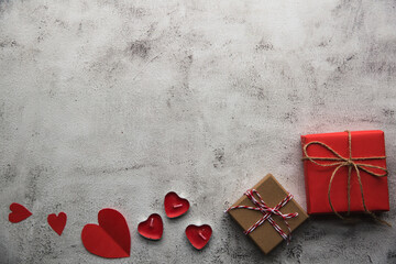 Valentine's Day, Gift box with a ribbon, candles and paper hearts. - 405450347