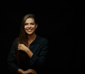 Smiling woman with big smile wearing black dress on black background.