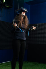 Young woman in VR headset enthusiastically watches video with full immersion in virtual reality club