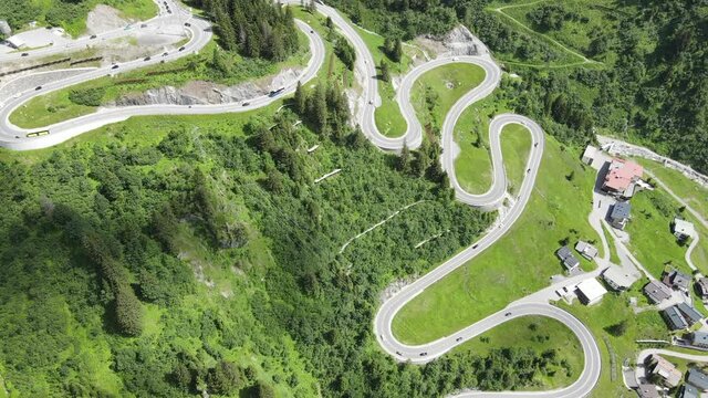 pass stra&szlig;e schl&auml;ngelt sich &uuml;ber fels und wiesen bis hin zu einer alten gallerie wo autos und busse anreisen und abreisen