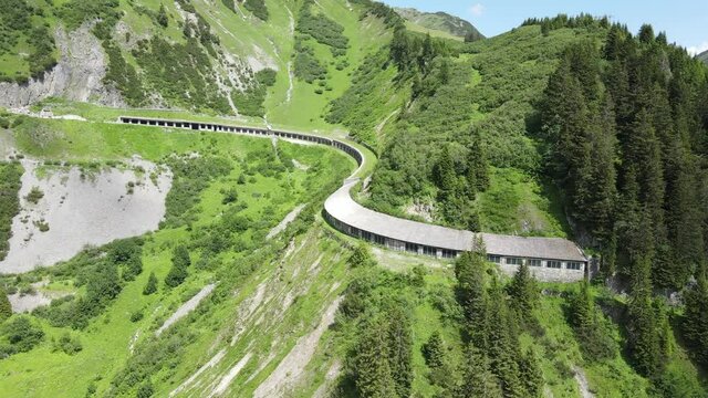 die hochalpenstra&szlig;e richtung lech zeigt eine alte gallerie die &uuml;berdacht ist un im fels und saftigem gr&uuml;m steht