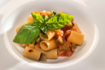 Italian pasta Mezzi Paccheri with tomato and eggplant sauce with basil leaves