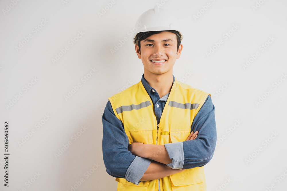 Wall mural asian engineer with crossed arms standing on background