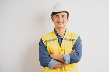 Asian engineer with crossed arms standing on background