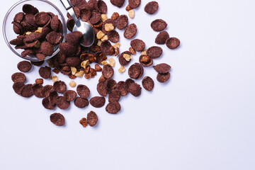  Bowl and spoon scattered flakes. Healthy breakfast on a gray background with blank space.