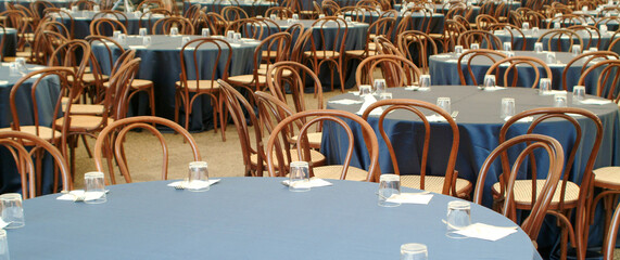 many round tables in preparation for a lunch at a large meeting
