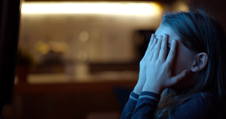 Side view of little girl watching scary movie at home on tv at home