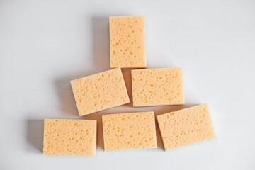 Yellow porous sponges on a white background. Copy, empty space for text