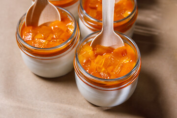 Persimmon and whipped cream smoothie in a glass jar. Wooden spoons in jars.