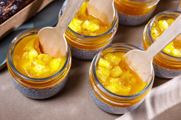 Persimmon and whipped cream smoothie in a glass jar. Wooden spoons in jars.