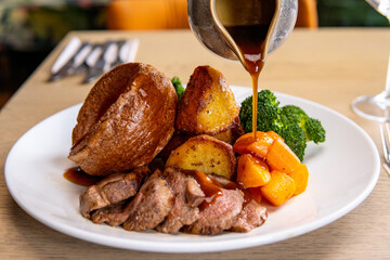 Gravy being poured on roast dinner 