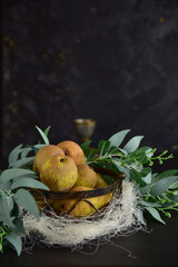 Basket with green juicy pears on a black background.