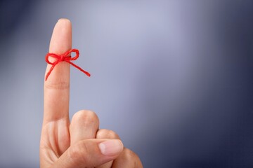 Red thread bow on a human finger