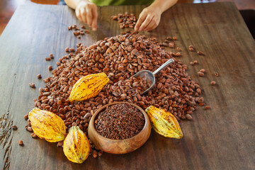 cocoa nibs and cocoa fruit on wooden table