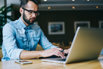 Focused male freelancer using laptop during workday