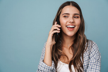 Beautiful young girl in casual wear using mobile phone