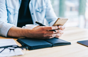 Entrepreneur using smartphone in workspace