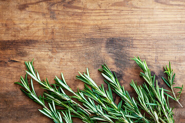 Fresh rosemary herb on a wooden  board. Top view rosemary with  copy space..