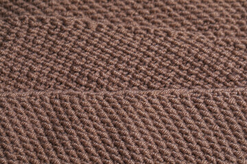 Texture of knitted fabric from brown yarn. Traditional hobby.