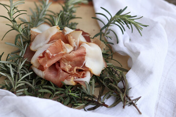 Side view of a smoked ham arrangement with fresh rosemary leaves