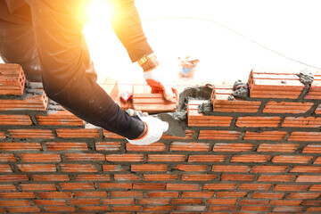 Brickworkers install bricks on the exterior walls with a knife putty trowel,