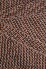 Texture of knitted fabric from brown yarn. Traditional hobby.