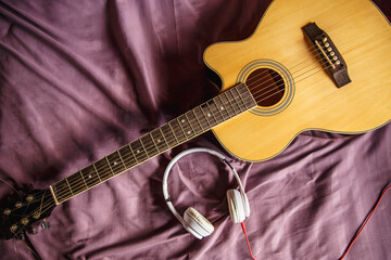 Obraz na płótnie Canvas Headphones and classical guitar in bed