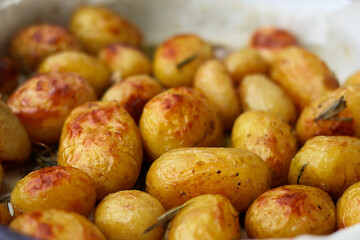 Side view of baked potatoes in olive oil and rosemary 